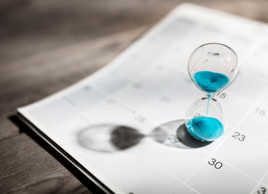 Hour glass on calendar concept for time slipping away for important appointment date, schedule and deadline