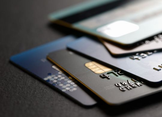 stack of multicolored credit cards on black background