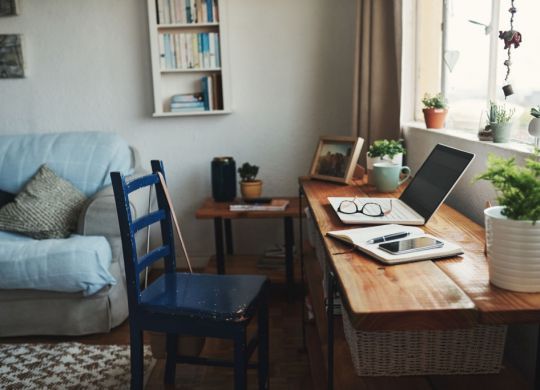 Cropped shot of technology and a notebook on a desk in an empty home office during the day