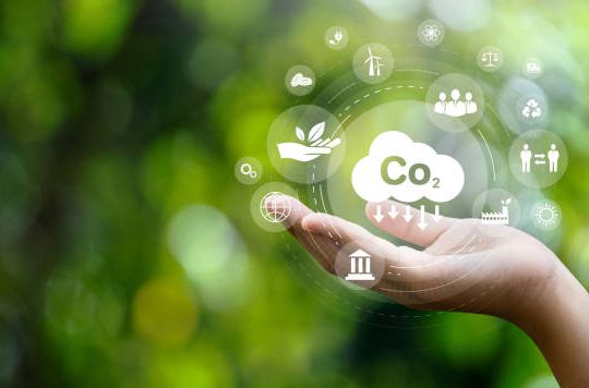 CO2 emission reduction concept in hand with environmental icons, global warming, sustainable development, connectivity and renewable energy green business background.